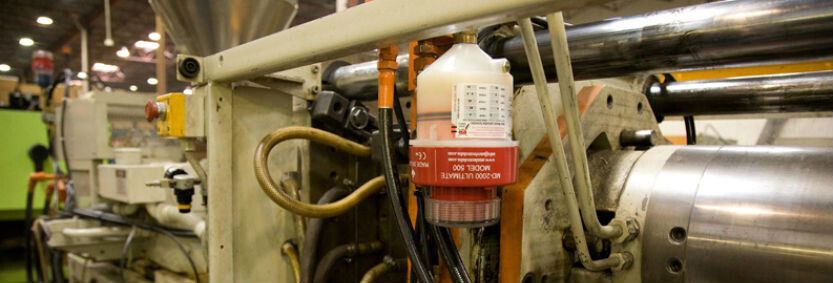 Automatic lubrication system fitted to plastic injection molding machinery, feeding 4 bearings on machine.