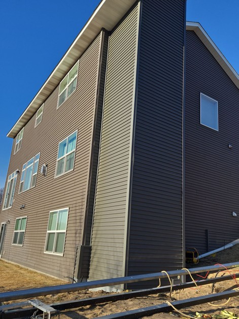 Home elevator installation with siding.