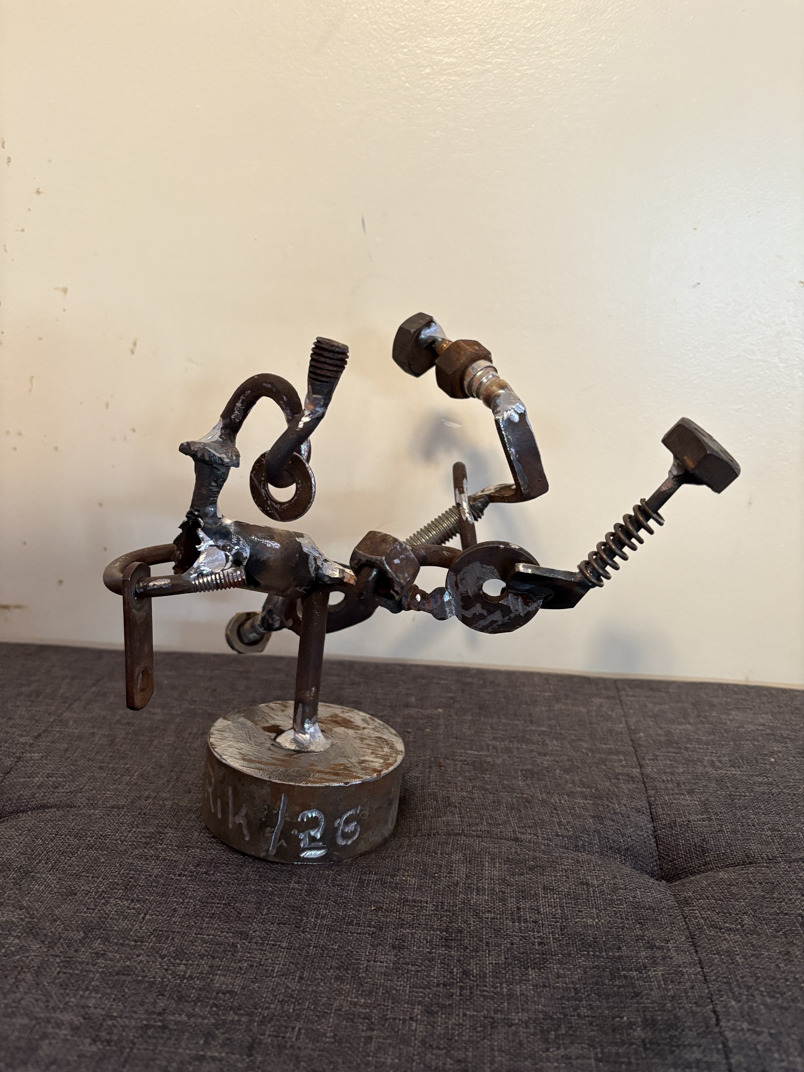 Abstract metal figure sculpture titled 'Movement Without Escape,' expertly welded from recycled bolts, screws, and nuts. Handcrafted by Saskatoon metal artist Rik Luczka, this dynamic small-scale sculpture captures a sense of fluid motion through industrial hardware. A unique example of Saskatchewan-made "found object" art, available for purchase or as a reference for custom nut and bolt metal commissions in Saskatoon.