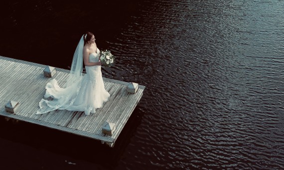 Drone photograph of a bride at Hensol Castle, Vale of Glamorgan, South Wales. The historic castle, sweeping gardens, and private lake are captured in warm evening light, perfect for dramatic and romantic wedding portraits.