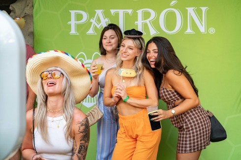 Group of Girls with green backdrop posing for a photo for the company Patron in Virginia Beach, VA.