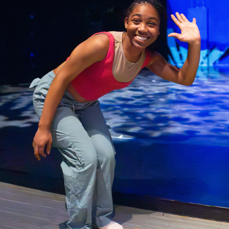 An RPW student smiles and waves.