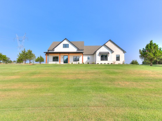 A two-story custom home built by Merryfield Homes in Highland Estates, Mustang, OK. The Juarez Home features stone and brick detailing, a landscaped front yard, and showcases the quality craftsmanship Merryfield is known for.