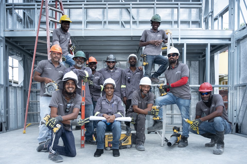 Professional group photo of construction workers at a steel frame job site.