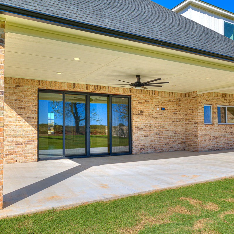 Rear exterior of the 10408 SW 51st Street home showing the extended covered patio with ceiling fan and sliding glass doors.