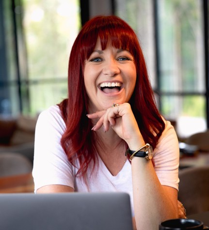 Bree Stedman, women's emotional breakthrough specialist and author of Own Your BS®, based in Newcastle NSW Australia, smiling, on laptop