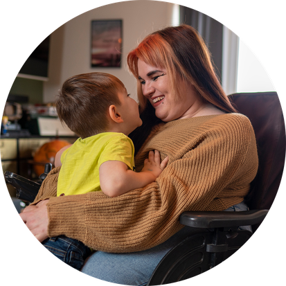 Smiling mother with child in wheelchair.