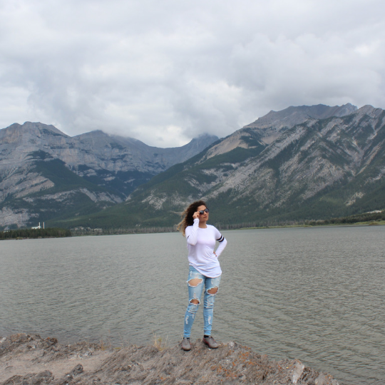 This is a photo of Tala Faraj standing by the scenic mountains in Banff, Alberta, Canada. 