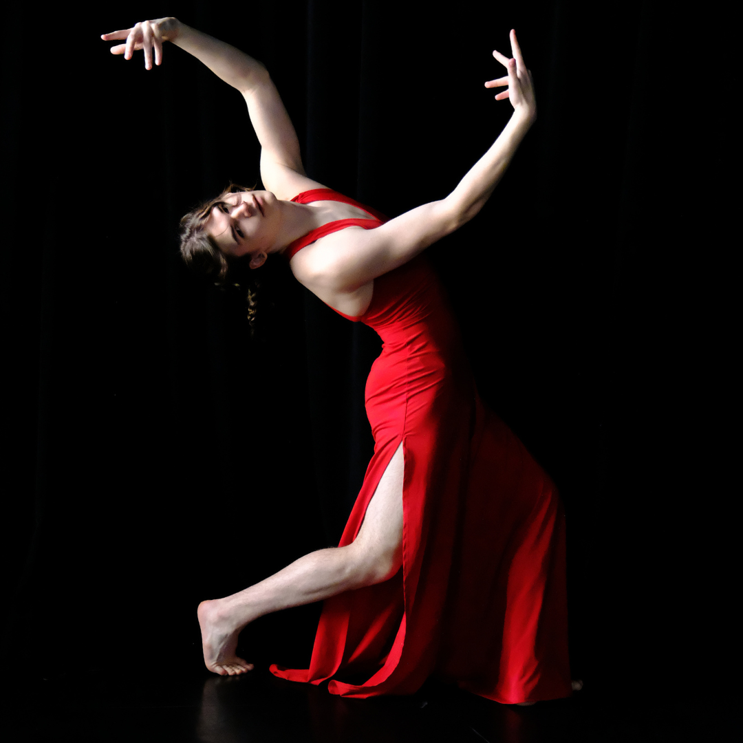 Ash poses in a red jumpsuit.