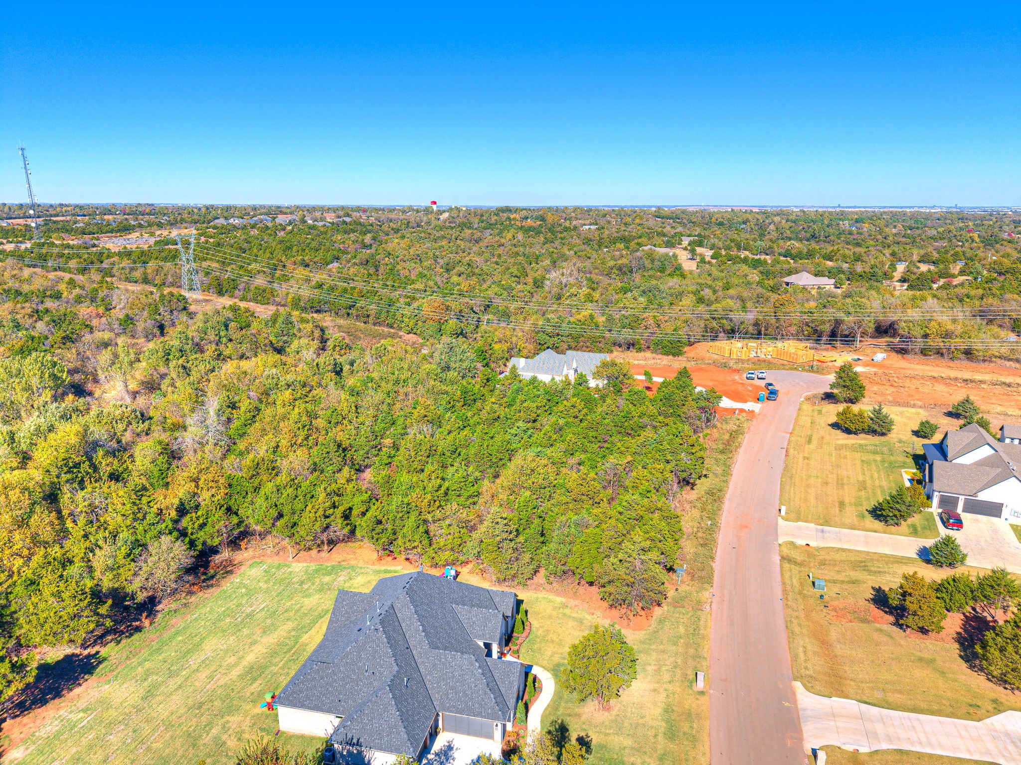 Aerial view of Lot 7 A in Highland Estates Mustang Oklahoma featuring a tree-lined acreage and neighboring homes.