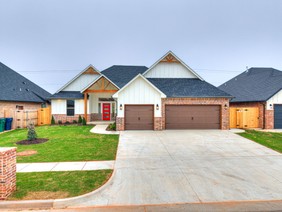 Completed custom home by Merryfield Homes located at 10428 SW 51st in Mustang, Oklahoma featuring a white modern farmhouse exterior, red front door, and three-car garage.