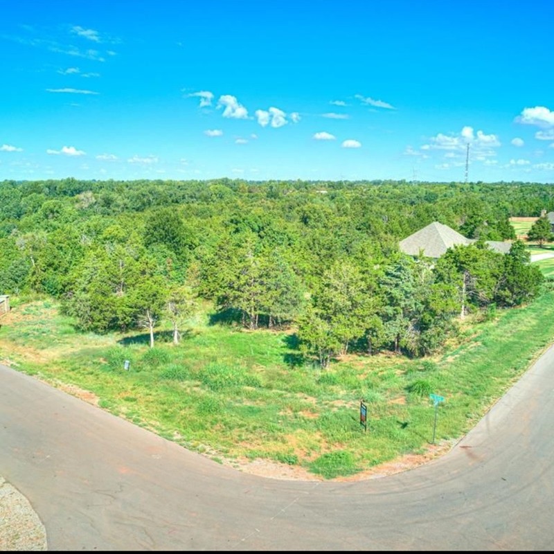 Drone photo of Highland Estates lots in Mustang OK, showing treed homesites and paved streets for custom homes.