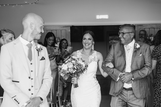 That first look as a bride walks down the aisle at Llanerch vineyard, South Wales wedding venue