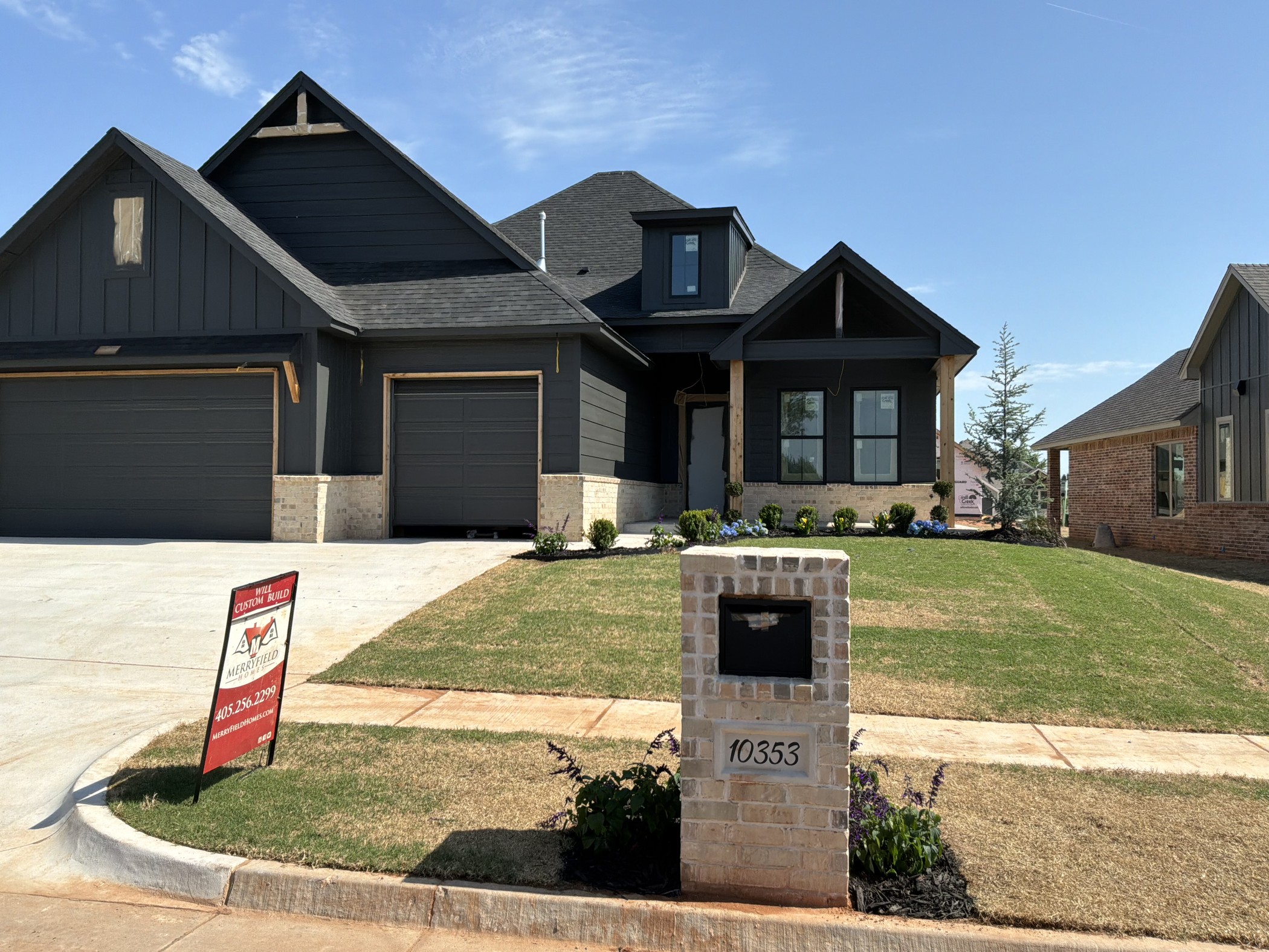 Completed custom home by Merryfield Homes in Mustang, Oklahoma featuring a three-car garage, modern farmhouse exterior, and professionally finished landscaping.