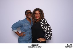 Two girls posing in front of a white backdrop at the Yellow Holiday Social in Chesapeake, VA.