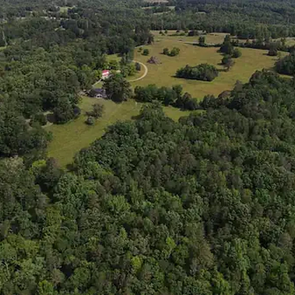 Stunning aerial view of the entire 127-acre National Campus property showing the expansive fields, forests, and riverfront location in Pacolet, SC