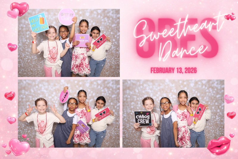 Children enjoying a Valentine-themed photo booth at the GRES Sweetheart Dance 2026, smiling and holding colorful props in front of a glittering backdrop. Event photography featuring a festive pink design, heart graphics, and a classic photo booth setup.