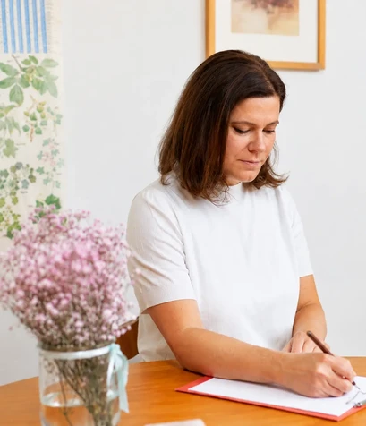 Patrizia Röllin schreibt Notizen in ihrer Praxis in Cham: Kinesiologie, Vitalfeldtherapie, Massage.