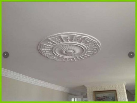 Picture of a ceiling where popcorn was removed. In the center is a classical medallion