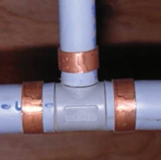 close up of the copper fittings and grey pipe in Poly B plumbing