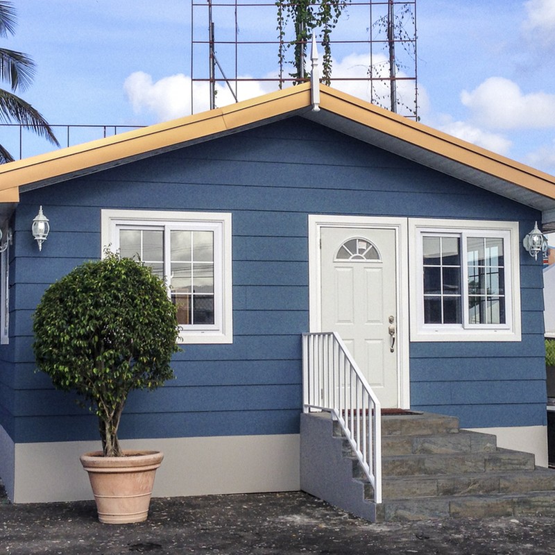 Frontal shot showing a small steel-framed model house, coloured in darkish blue colour.